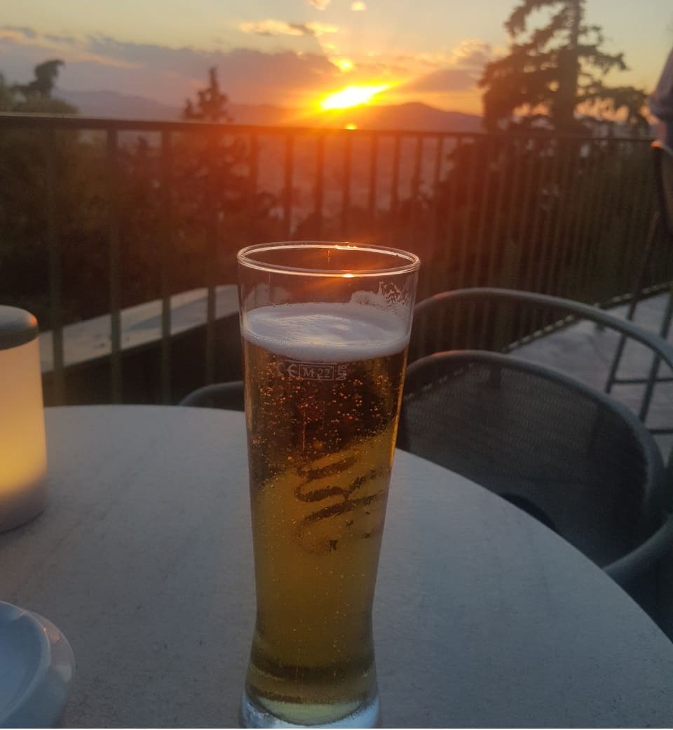 Cup of beer with sunset view from Prasini Tenta Lycabettus Hill's Restaurant